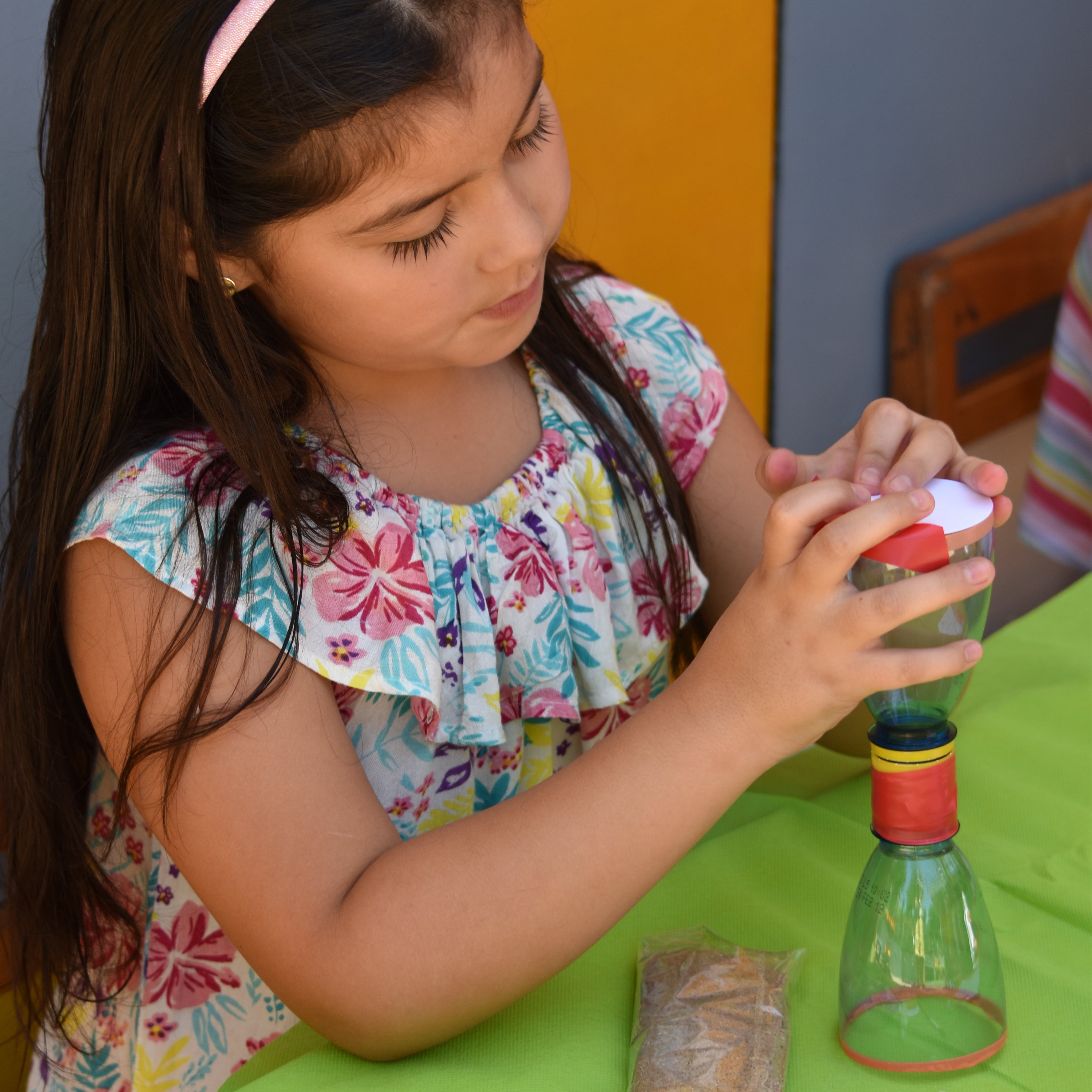 niña construyendo un reloj de arena a mano