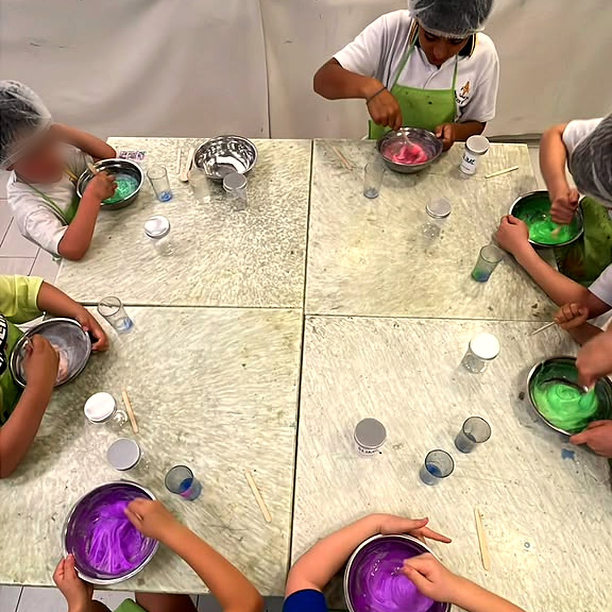 Niños preparando slime de colores en el taller de De Tin Marín en San Carlos de Apoquindo
